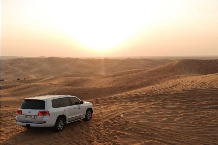 Experience the stunning beauty of red sands under a golden sunset as you embark on a 4x4 adventure through the iconic Arabian desert landscape. Embrace the journey!